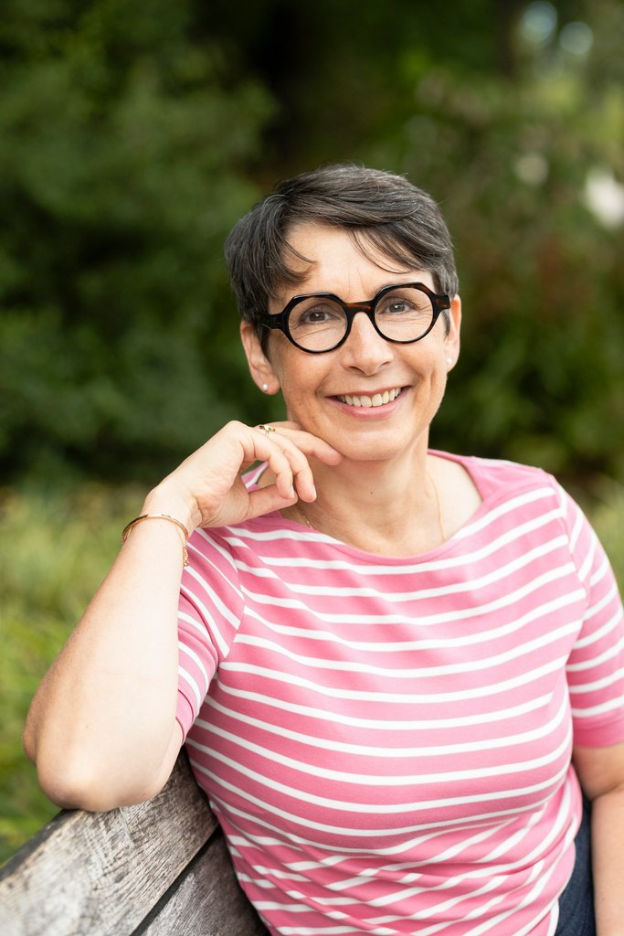 Portrait de Véronique Gachet, coach et conseillère bien-être, souriante en extérieur.
